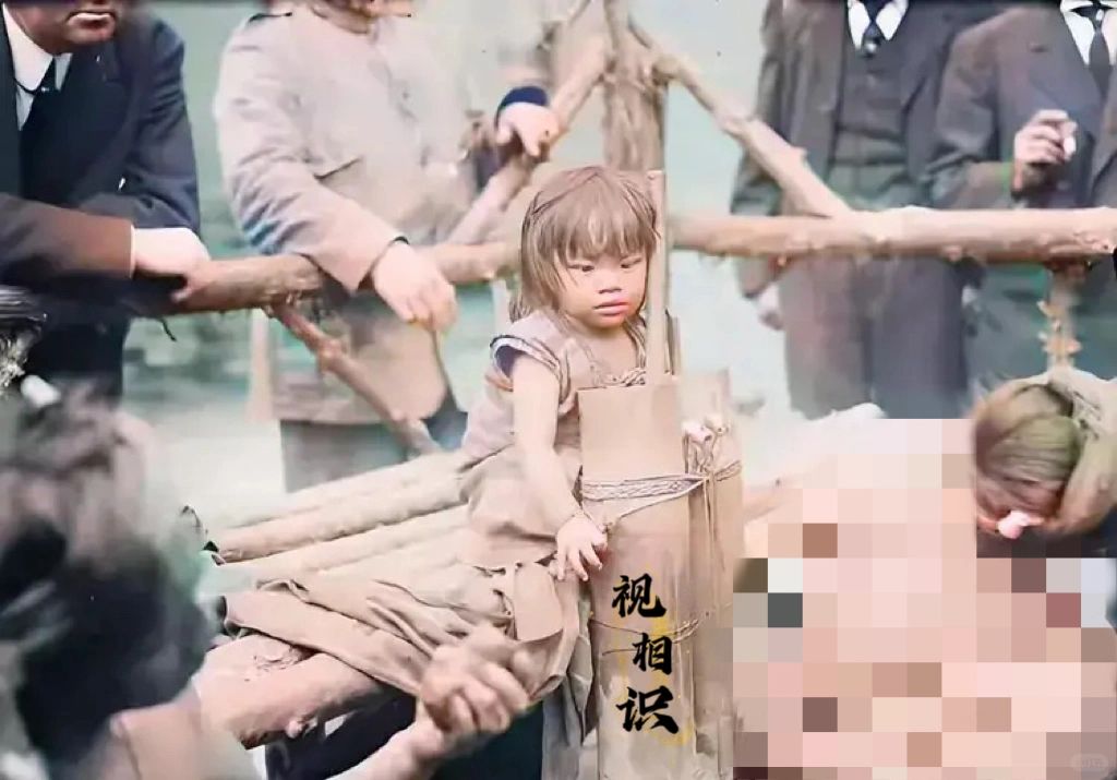 1906年，美国纽约，一对来自菲律宾的母女被展览的旧照，画面中的小女孩坐在简陋的...