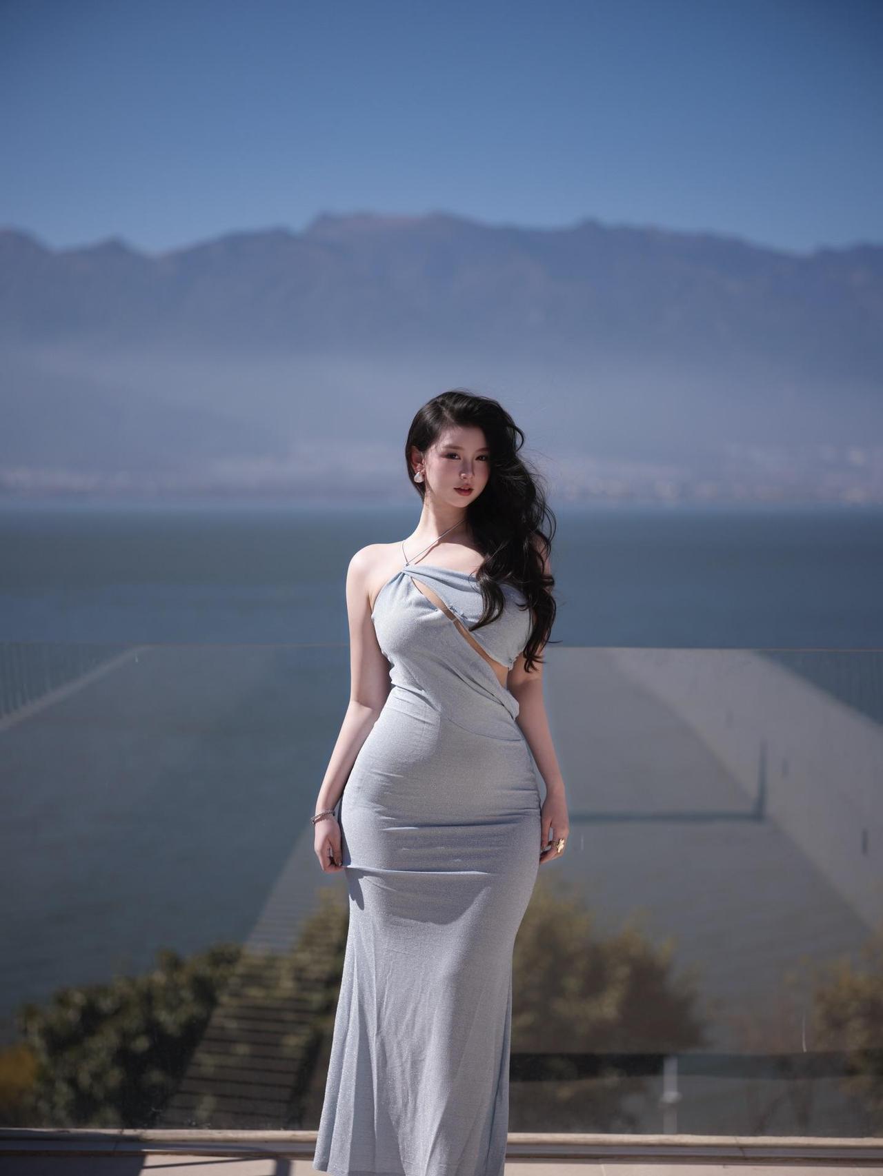 无需刻意摆姿，
她只是静静地站在那里，
让阳光替她描边，让海面替她作画。
那一刻