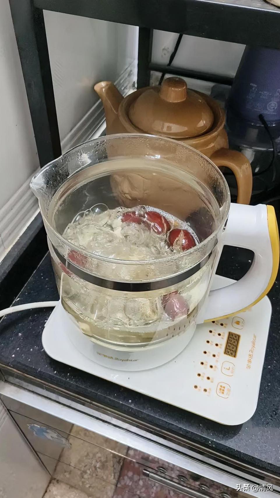 看这桌上的养生壶正咕嘟着，里头银耳裹着几颗红枣，泡得软软糯糯的，水汽顺着玻璃壁往