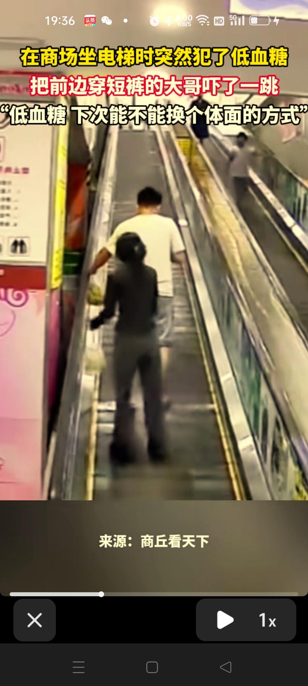 大哥边坐电梯边玩手机正看的入迷，突然间被一个女人拉着裤子往下拉，大哥吓了一跳，边