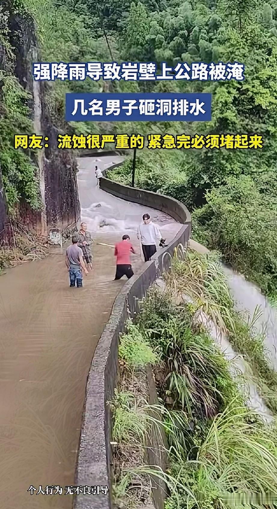 四川盘山公路上，因为下暴雨导致岩壁下的公路被淹，几位路过的卡车司机自发组织拿上工