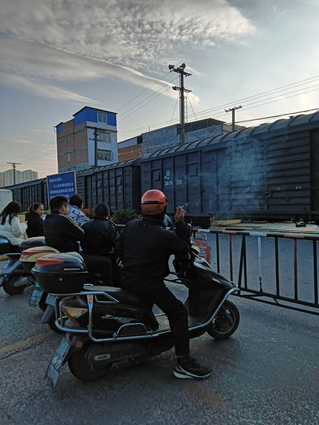 下午坐车经过贵港市港北区铁路新村铁道口旁，道口落闸一辆载货的火车鸣着笛开过。经过