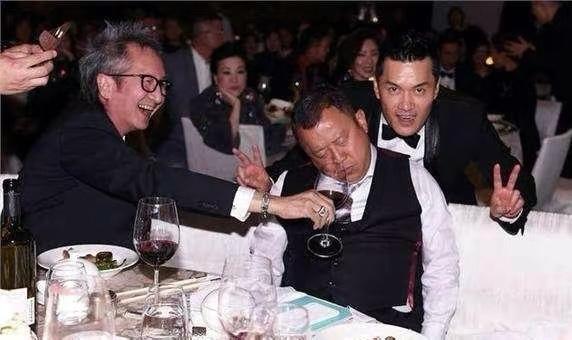 画面中的吕良伟西装革履，朗目疏眉，英姿勃发，丰神俊逸；其面前的曾志伟红光满面，垂