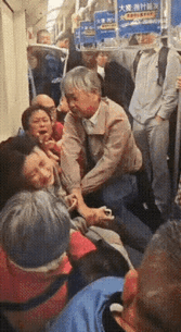 地铁车厢内站立的老太和有座位的老太，对旁边坐座的年轻女士进行抓头厮打，吐唾沫，要