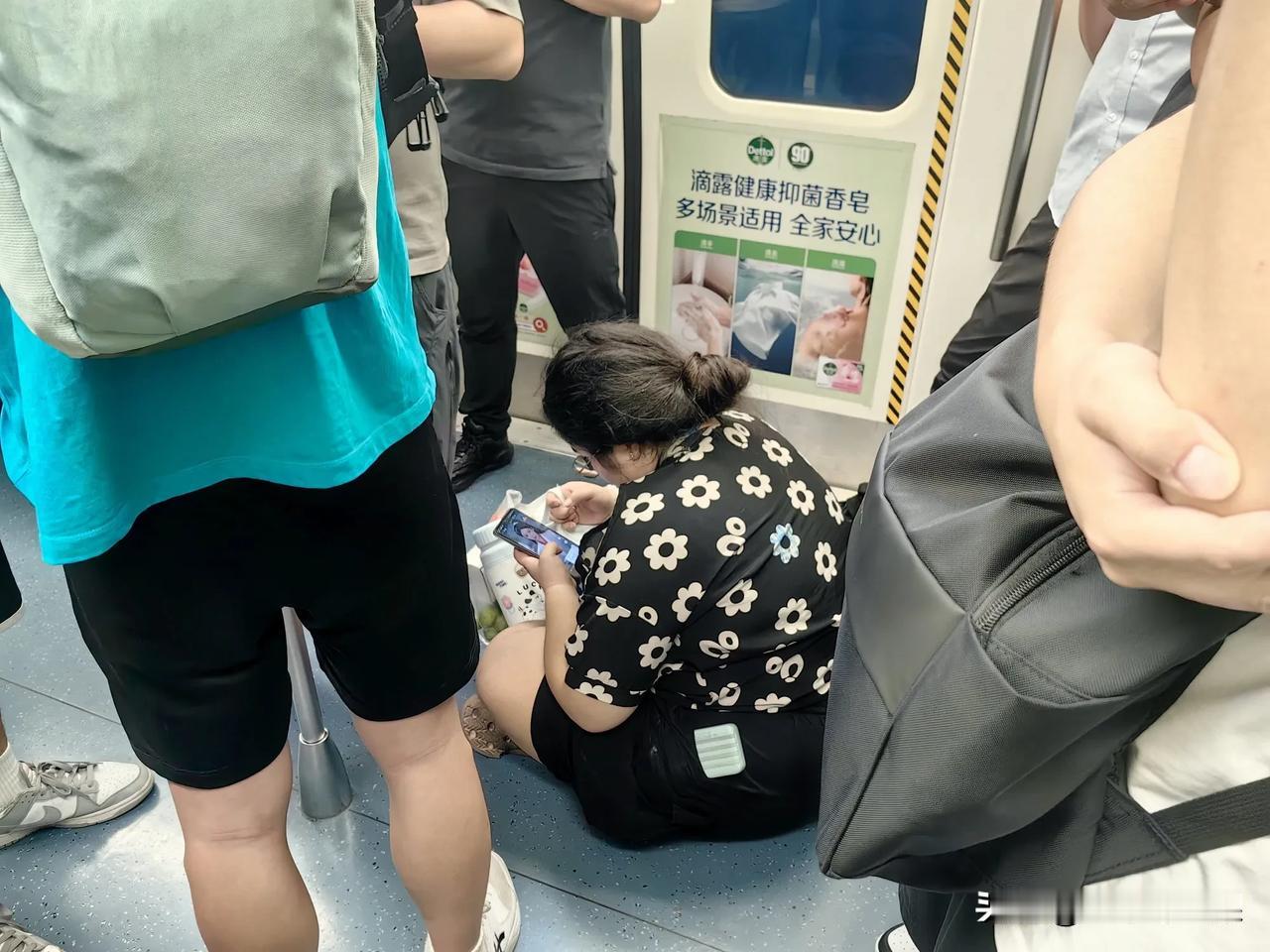 不在乎别人眼光，这女子上车后直接一屁股坐在了地板上。下班，乘坐成都地铁一号线回家