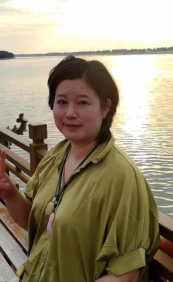 要是没人提醒，打死我也不敢信。

眼前这个挤着眼睛、双下巴若隐若现的短发大姐，竟