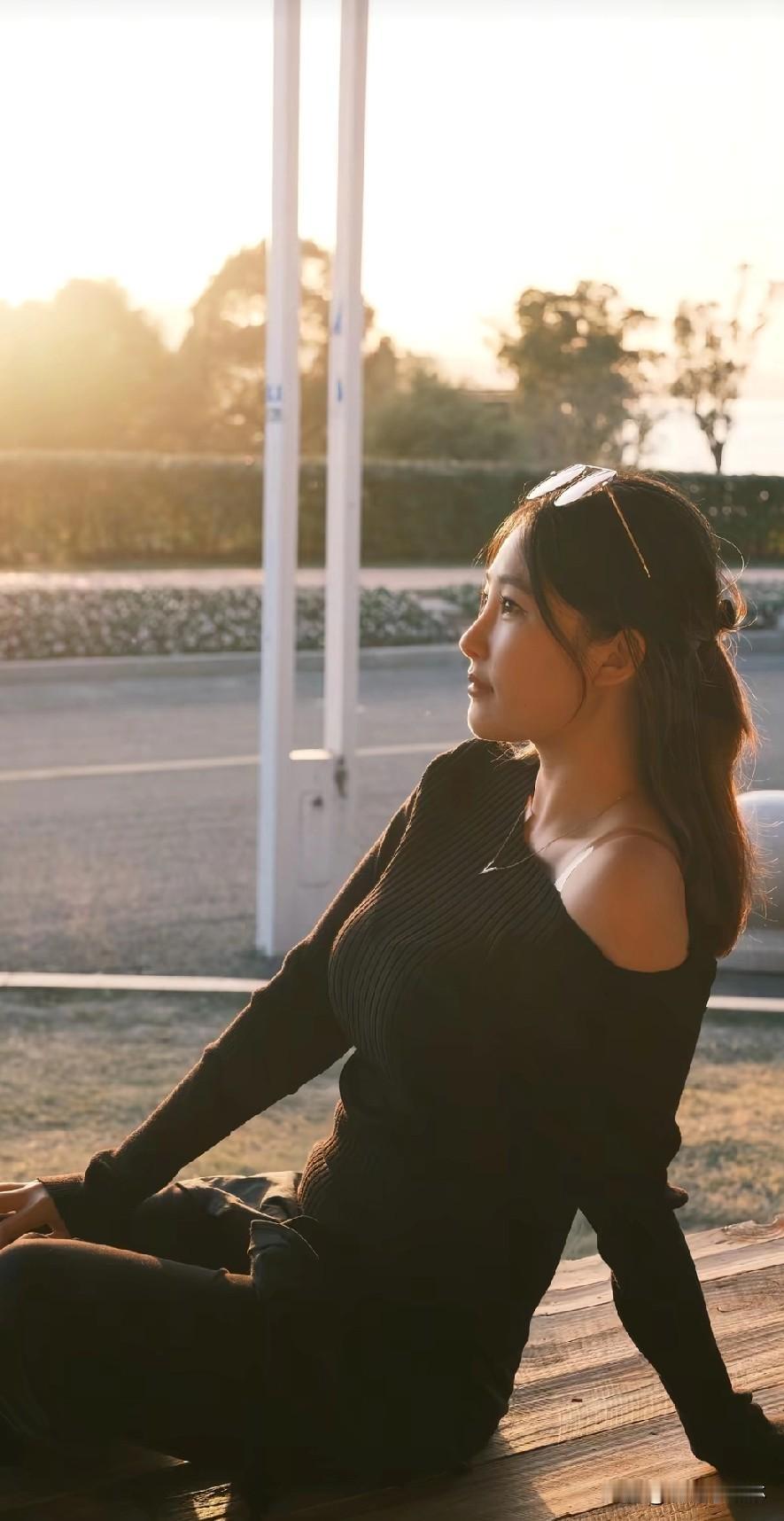 女孩黄昏时分，独自倚栏，静享宁静时光。