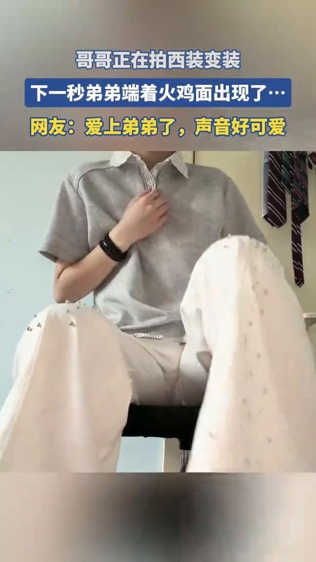 哥哥正在拍西装变装，下一秒弟弟端着火鸡面出现了。
网友：爱上弟弟了，声音好可爱。