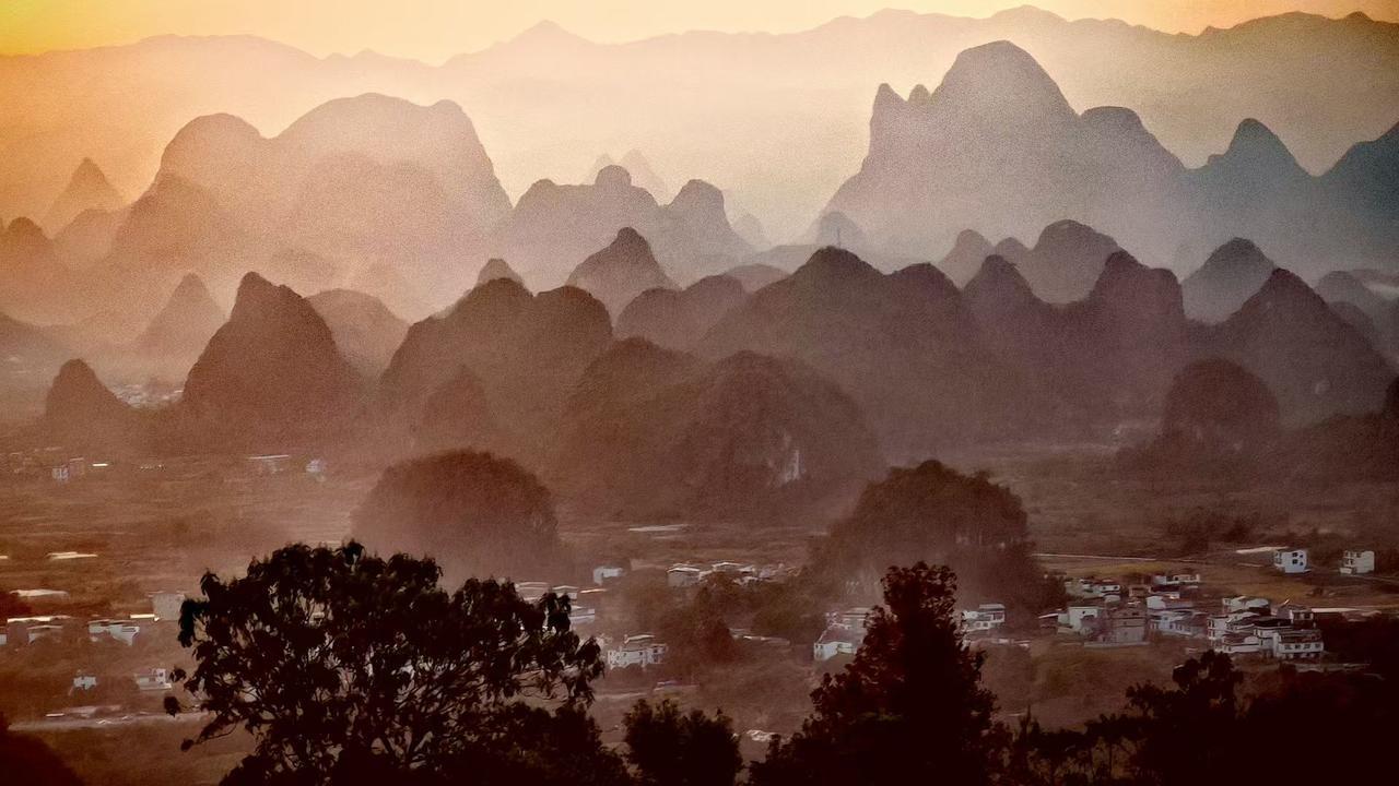 群山把黄昏叠成雾色的浪，村落卧在山坳里，像被光阴轻拢的温柔褶皱。
🍂 暮色给峰