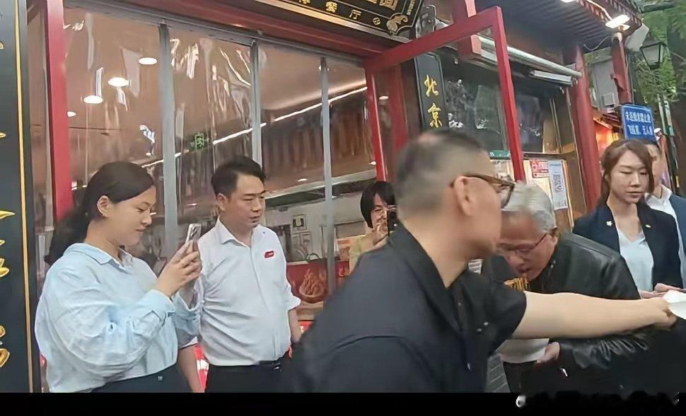黄仁勋去吃炸酱面！大热天穿皮衣，站在门口大口吃面条，高盛CEO 也在。黄仁勋以爱