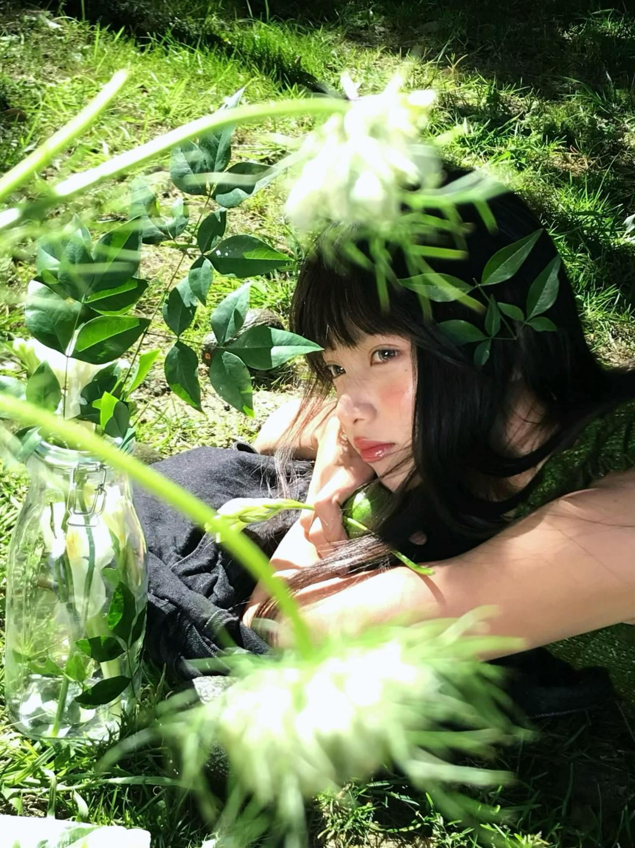 拍摄躺姿人像，需要摄影师以低角度拍摄，让人物与草地、紫花完全融为一体，构建出“躺