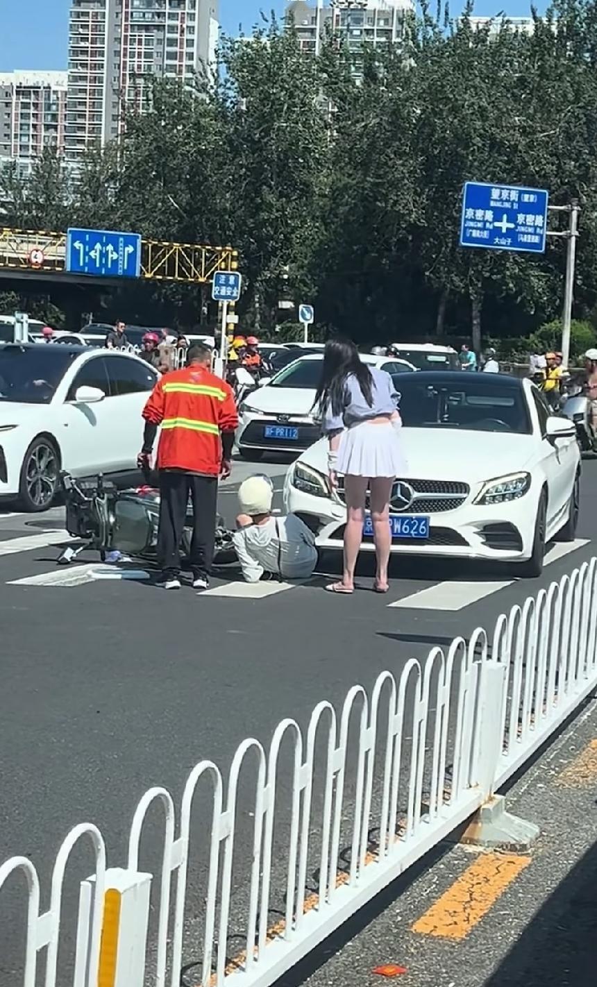 奔驰女司机摊上事了，在斑马线上撞到一辆电动车，电动自行车车主应该是受伤了。
再仔