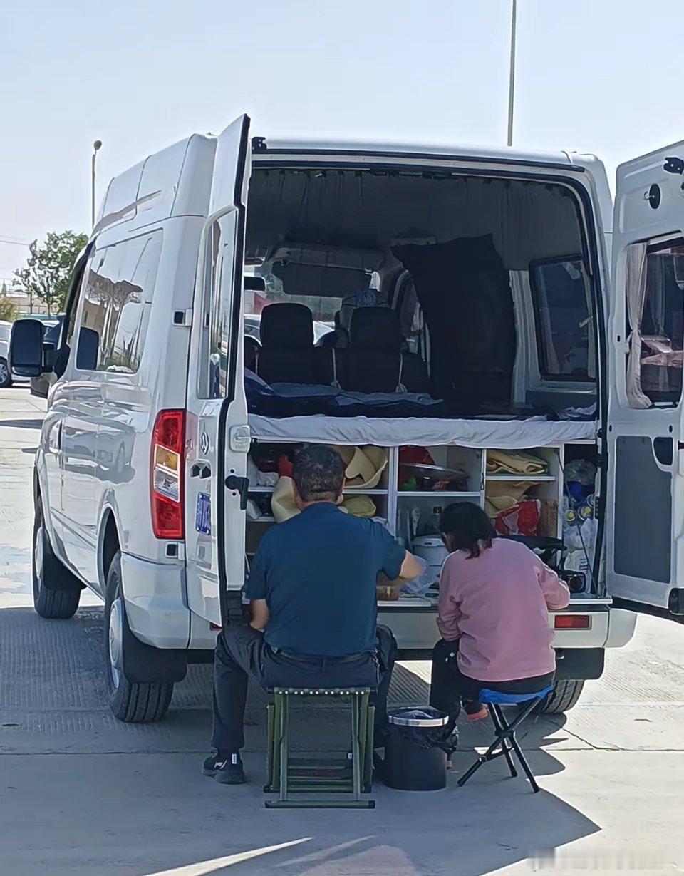 在219国道的一个服务区歇脚时，看到一对中年夫妇，在一辆改造的房车后面吃早餐早餐