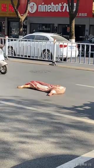 今天骑车上班，车流拥挤，人来人往，当走到市中心，看到前面有半扇猪肉。
过路的行人