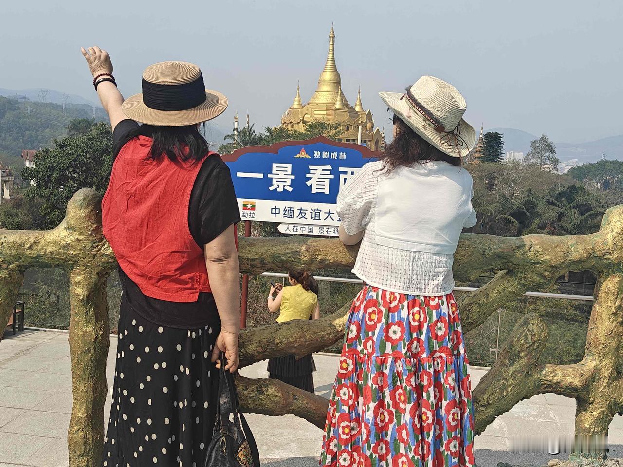 到中缅边境，铁丝网外的缅甸如同世外桃源，人少景单，一个缅甸人坐在草棚里，旁边有两