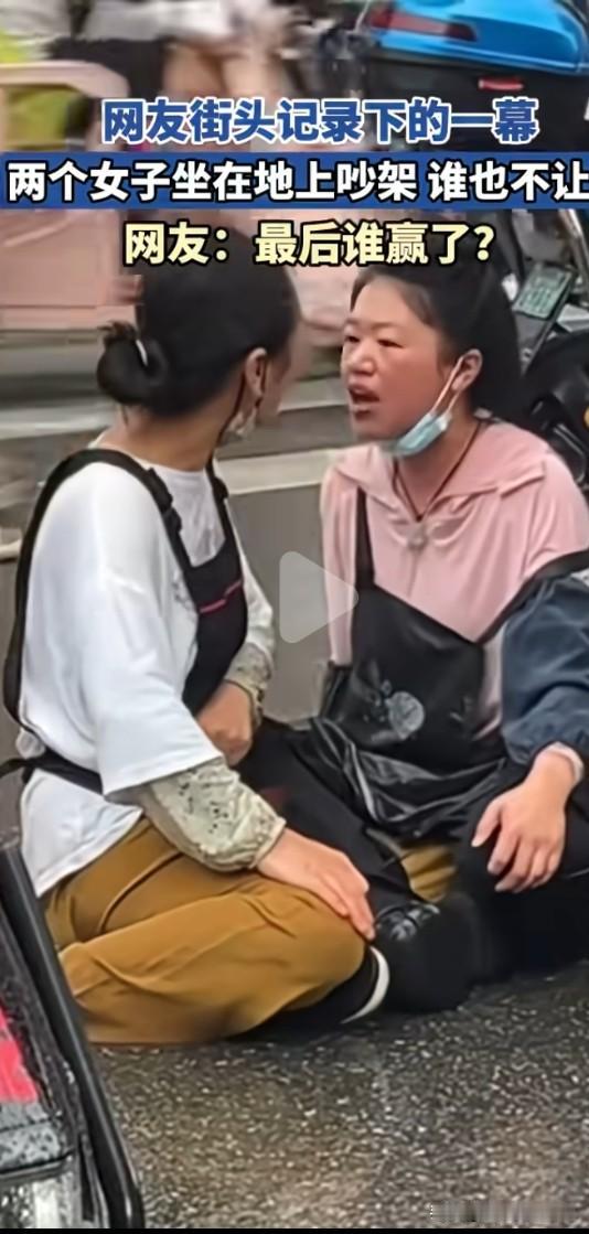 街道上上演理性吵架一幕。两位大妈席地而坐，只动口不动手，嘴对着嘴争吵，互不相让。