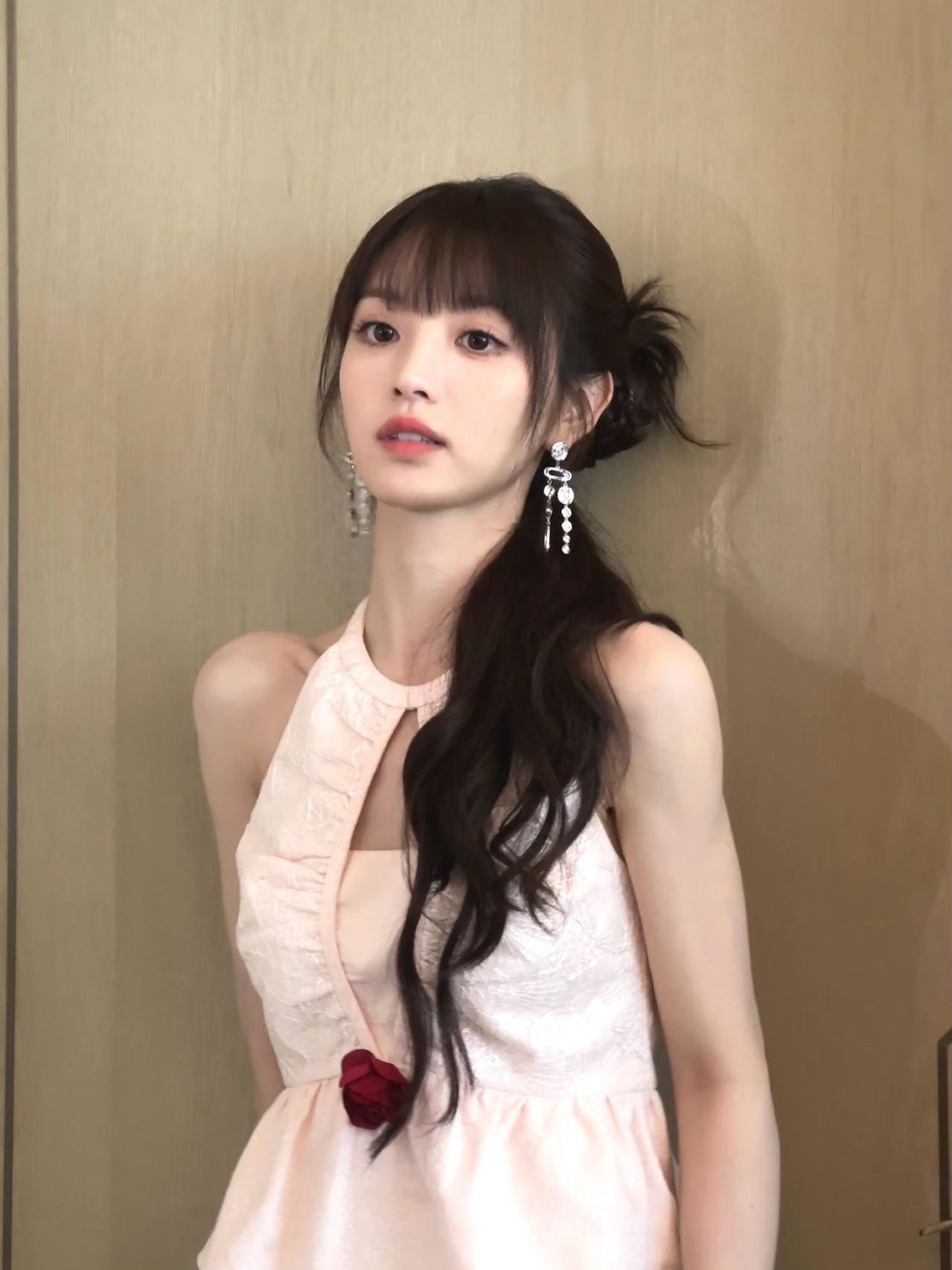 田曦薇
浅粉的衣料裹着细碎的光，
像把春日的云，裁成了贴身的温柔。
那朵暗红的玫