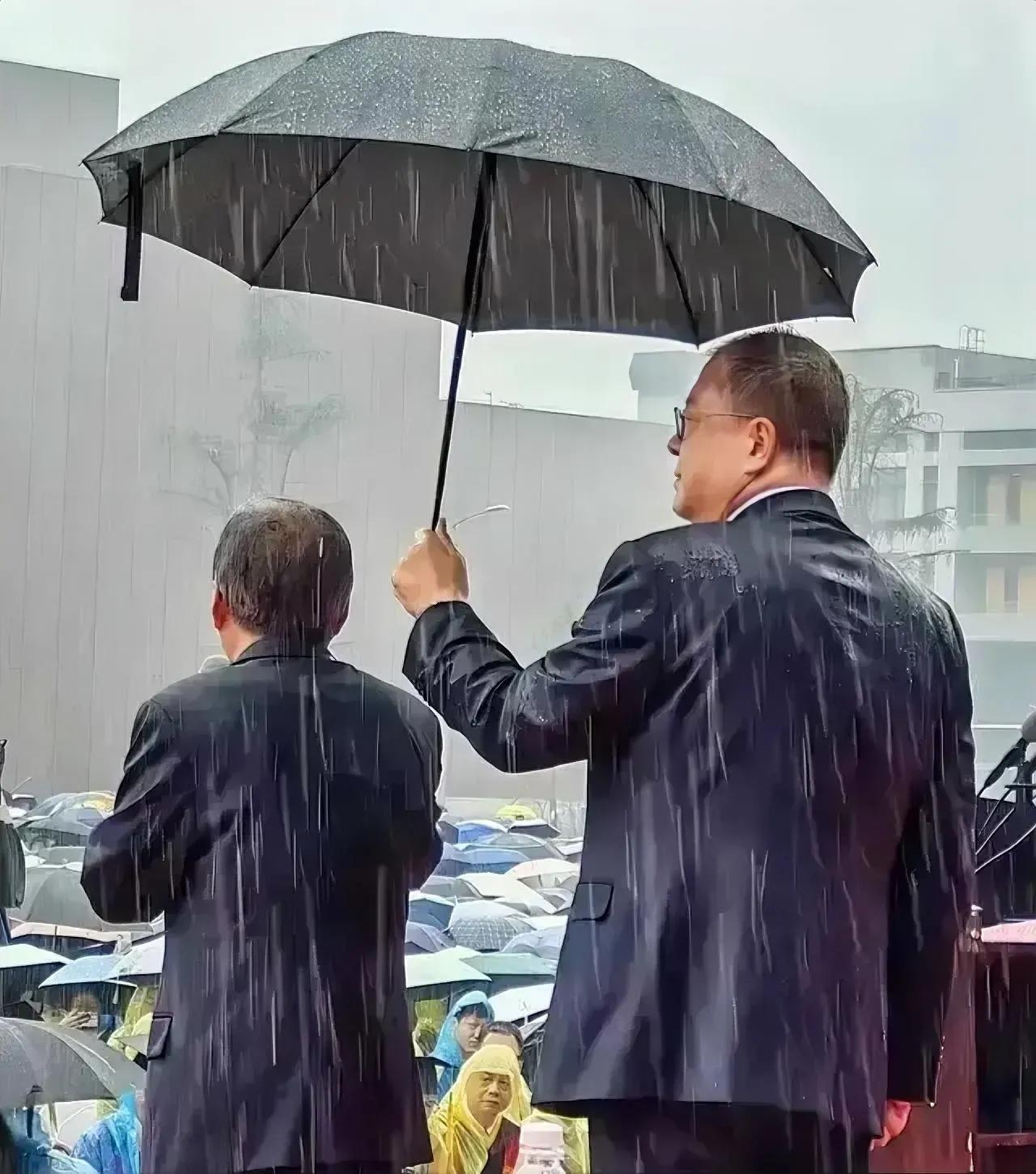 在雨中，
在西安交大，
在西安交大毕业典礼上，
一个男人为另一个男撑起了一把雨伞