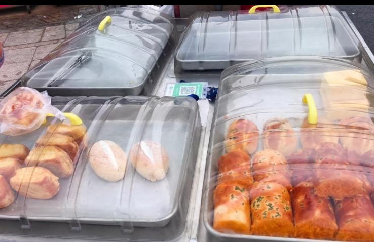 最近郑州街边有个面包摊突然火了，起因特别暖心——一个骑电动车的小女孩追着摊主喊“