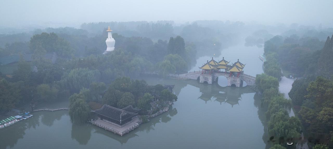 雾锁扬州瘦西湖：深秋清晨的水墨仙境
 
深秋的扬州，总爱用一场薄雾给瘦西湖裹上轻