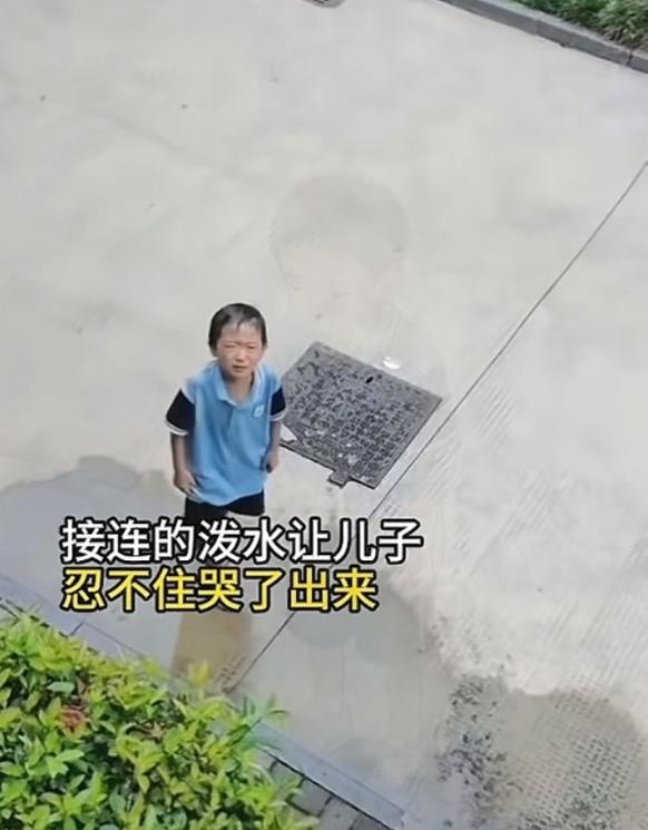 妈妈让儿子站在楼下，毫不留情地朝儿子泼水，原因是因为，儿子在学校三楼，多次向楼下
