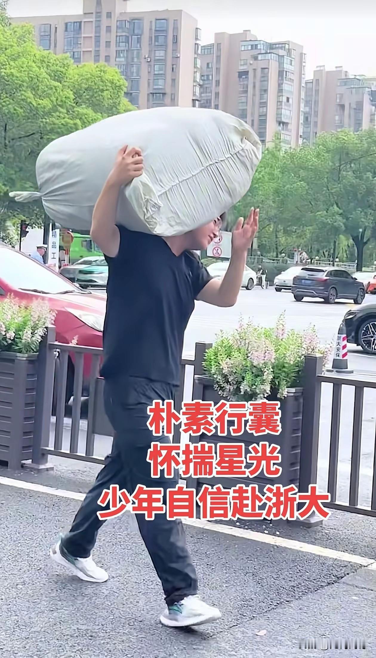 浙大新生入学，这个高大的男生自己扛着蛇皮袋，虽然扛着也比较吃力，但他还是坚持扛着
