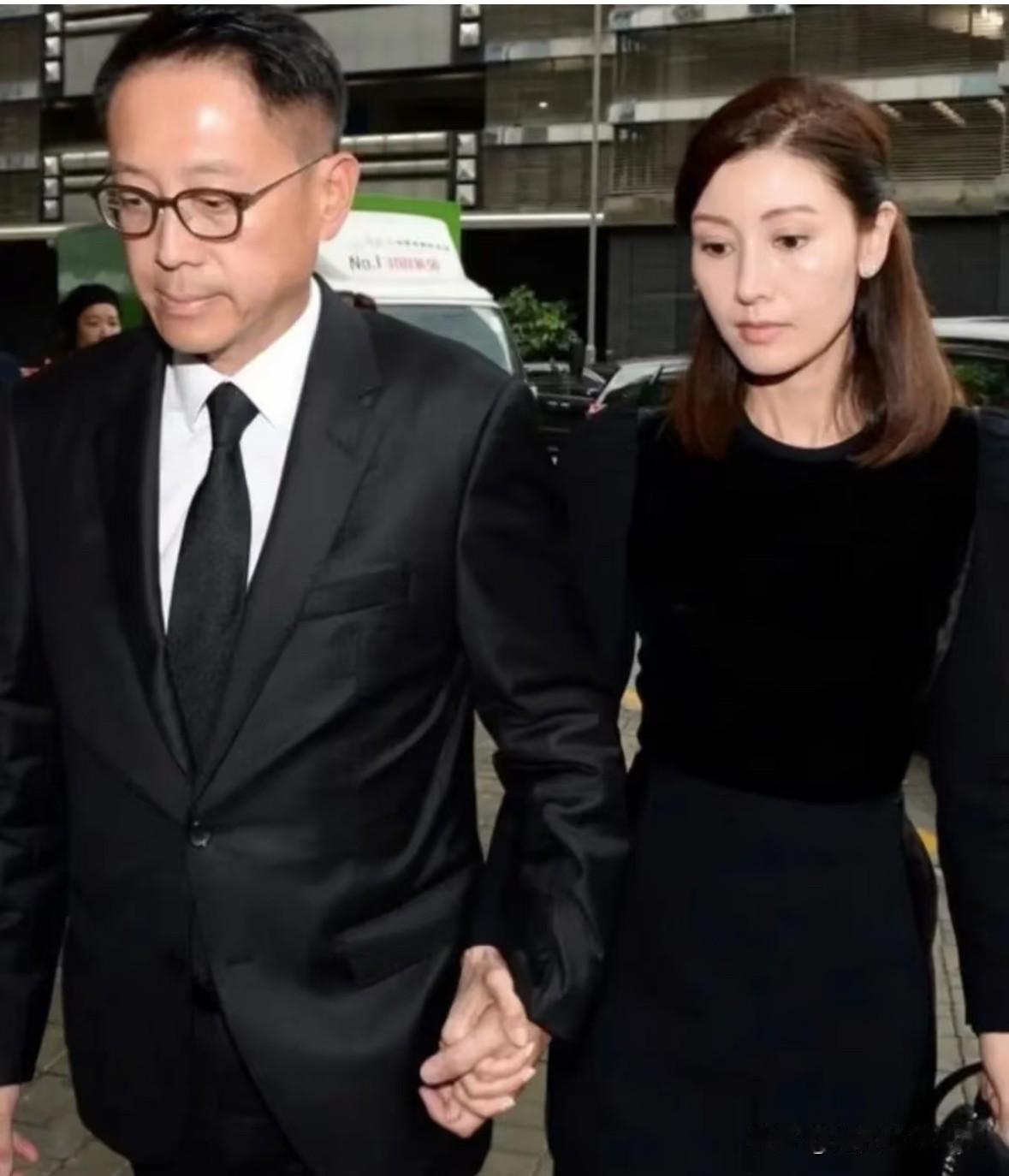 一身素黑，二人紧紧牵着手缓步同行。富三代许晋亨西装领带白衬衫，穿着整齐，沉稳内敛