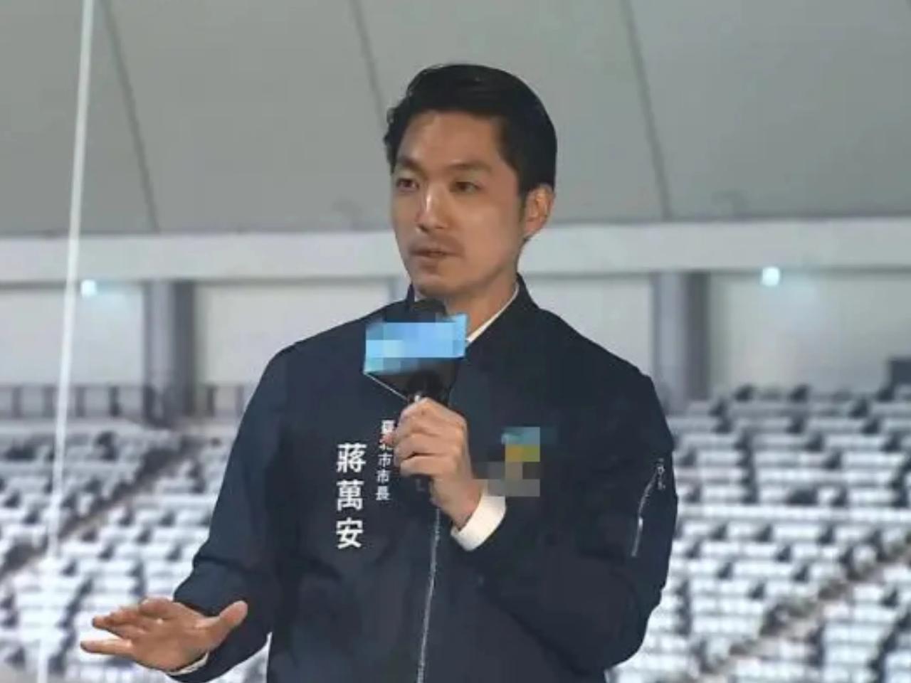 蒋万安穿的夹克衫上印着姓名、职务，这个很好辨识。这比胸前挂个小的工作牌显眼多了。