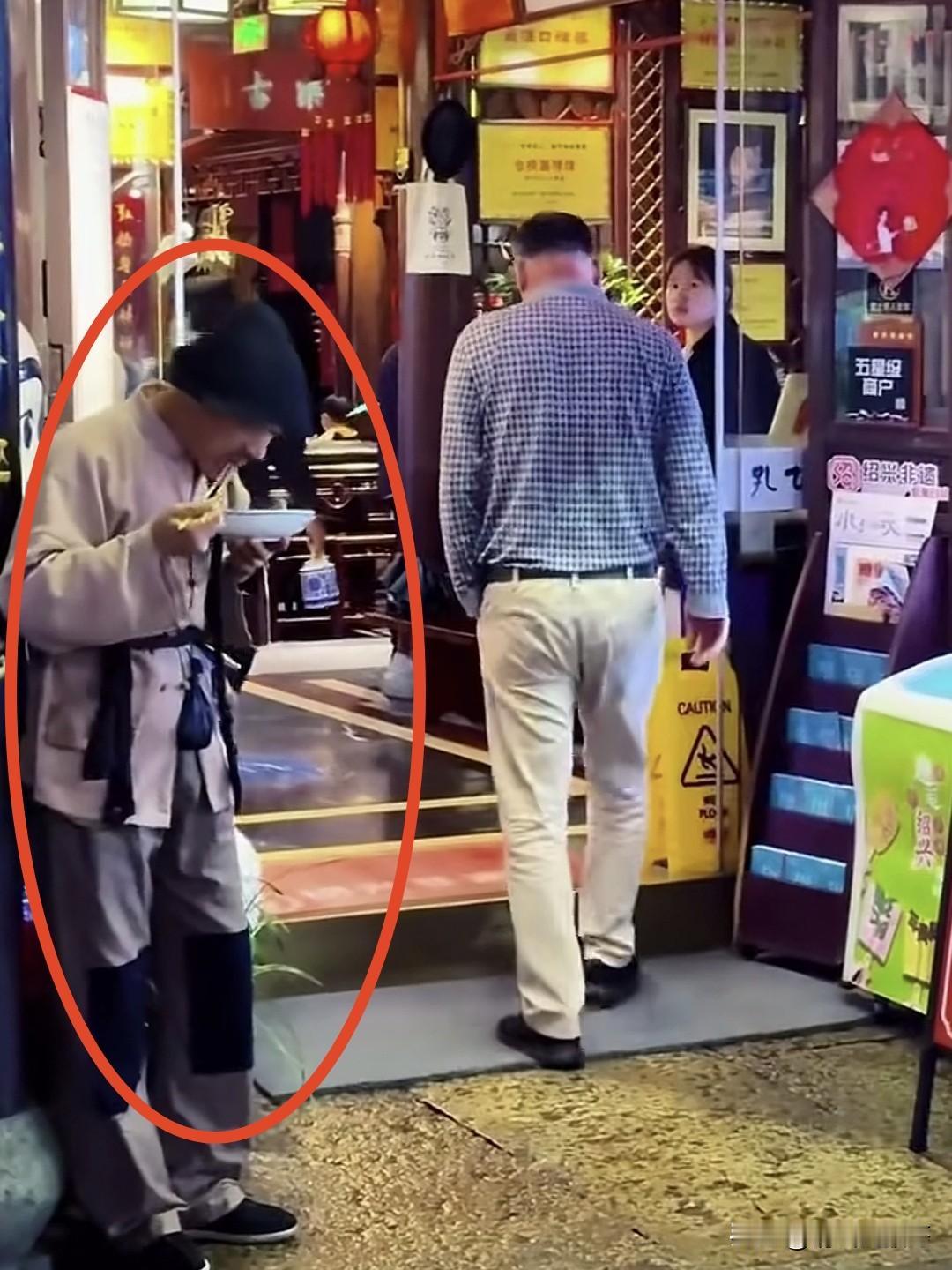 这个站在酒店门口破衣烂衫端着碗吃饭的人不是乞丐，而是孔乙己酒店特聘的NPC，这是