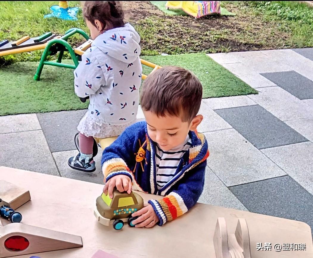 今天宝宝在幼儿园练习骑小车，旁边一小男孩在搭积木模型小汽车。