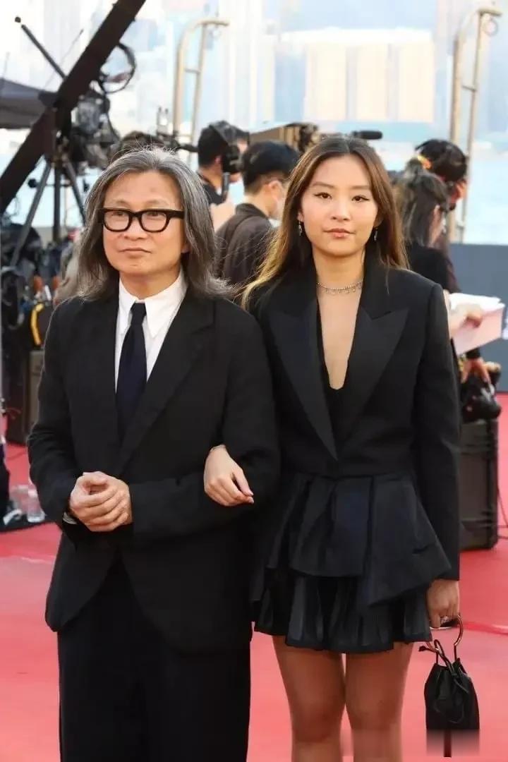 吴君如的女儿挽着她的父亲陈可辛出现在红地毯上。刚刚过完17岁生日的陈是知，身高、