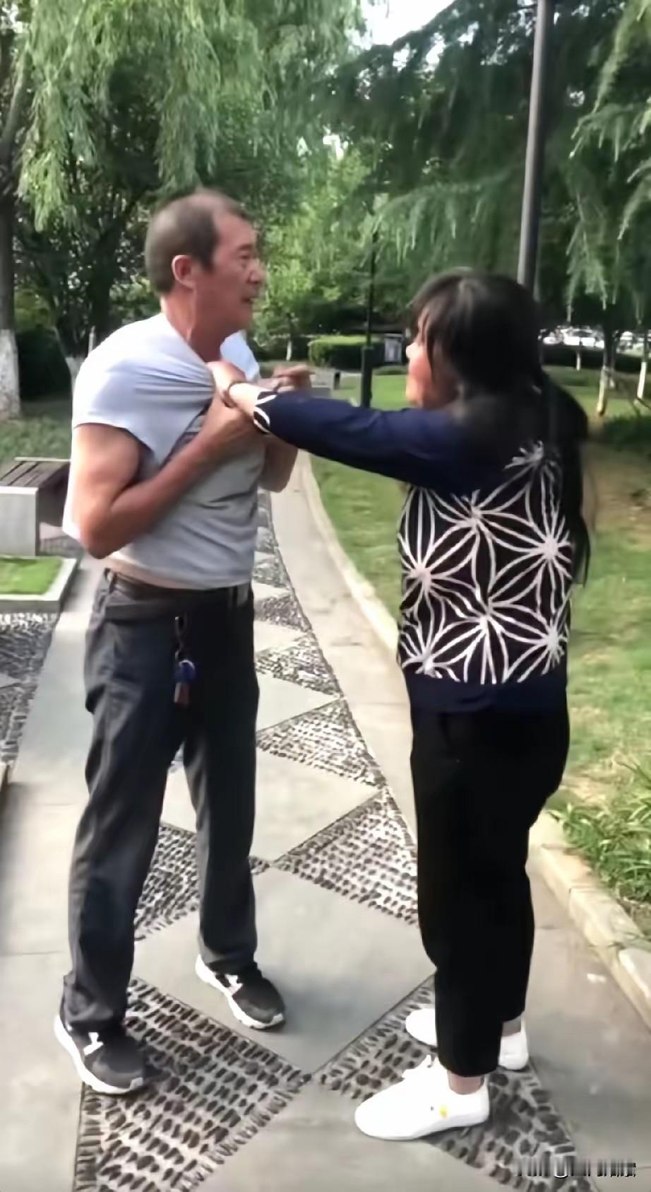 一公园内，大妈扯着一大爷的衣服不让走，嘴里骂骂咧咧的，任凭大爷怎么说，大妈就是不