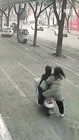 马路牙子上，电动车后座的女人，伸手就推了一把前面骑车的男人。
车身猛地一晃，她整