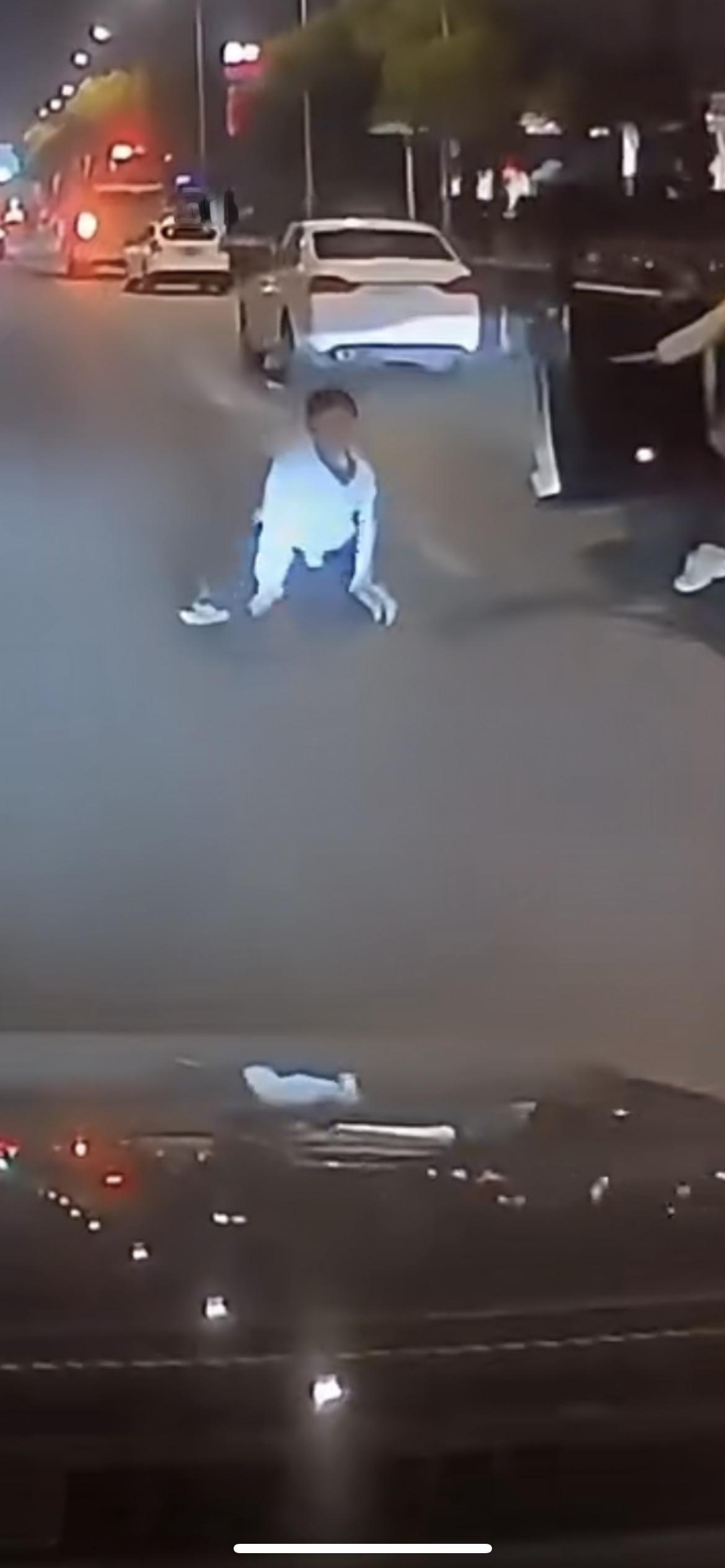 1月28日江苏，男孩被女子用力推倒摔在马路中间，男子开车经过时差点碾压到男孩，男