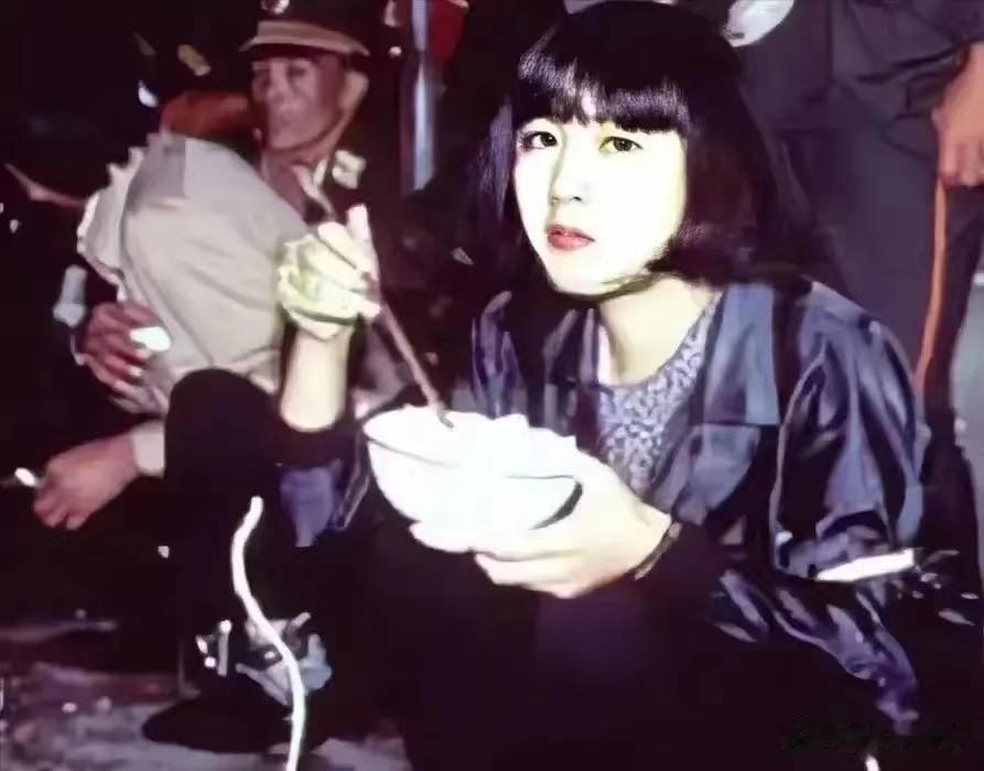 1991年，在云南昆明，一名女囚犯正在吃去法场之前的“断头饭”。
她的双手虽然被