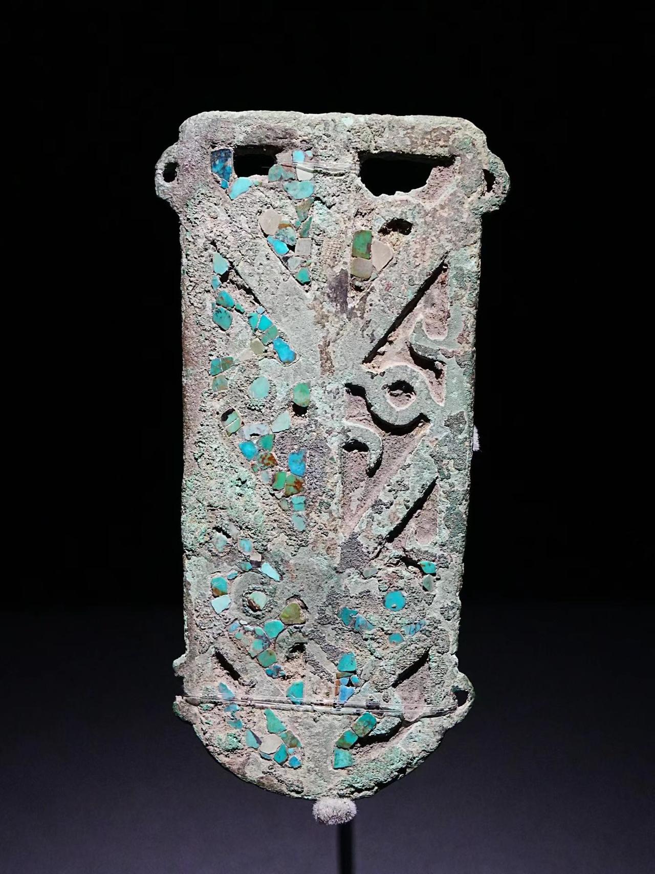 三星堆出土的绿松石铜牌
正面绿锈上也有织物印痕
考古团队鬼鬼祟祟地写到
这是“细