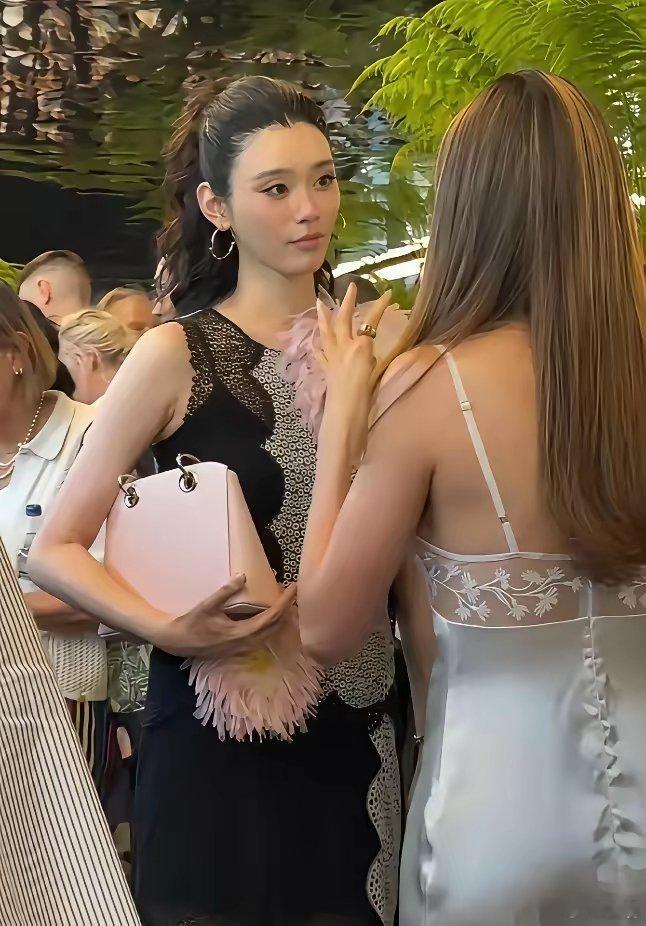奚梦瑶的表现着实令人惊叹。她与谷爱凌在前排愉快交谈，同时敏锐地捕捉到镜头的闪光，