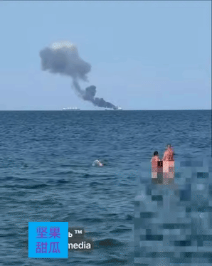 敖德萨市民这是犯罪啊，他们在海滩消暑纷纷对着海里被袭击的货船拍照，一对夫妻甚至一