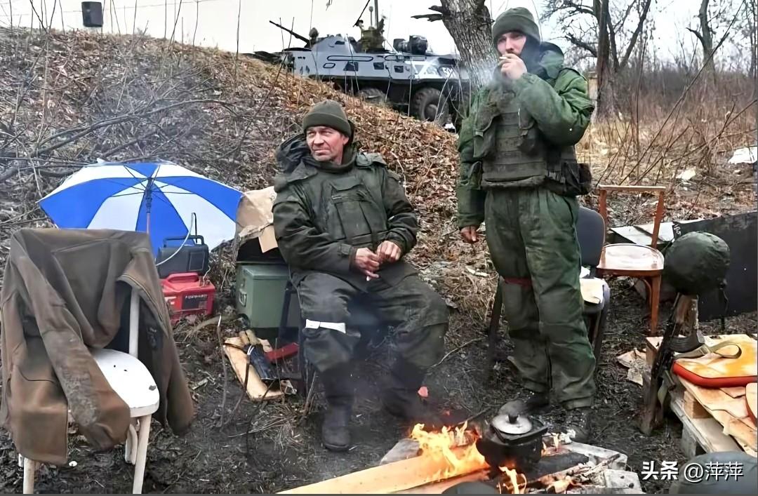 俄乌冲突中休整的俄罗斯士兵，一人坐着一人放松的吸着烟。战友为他们拍下了这一刻。