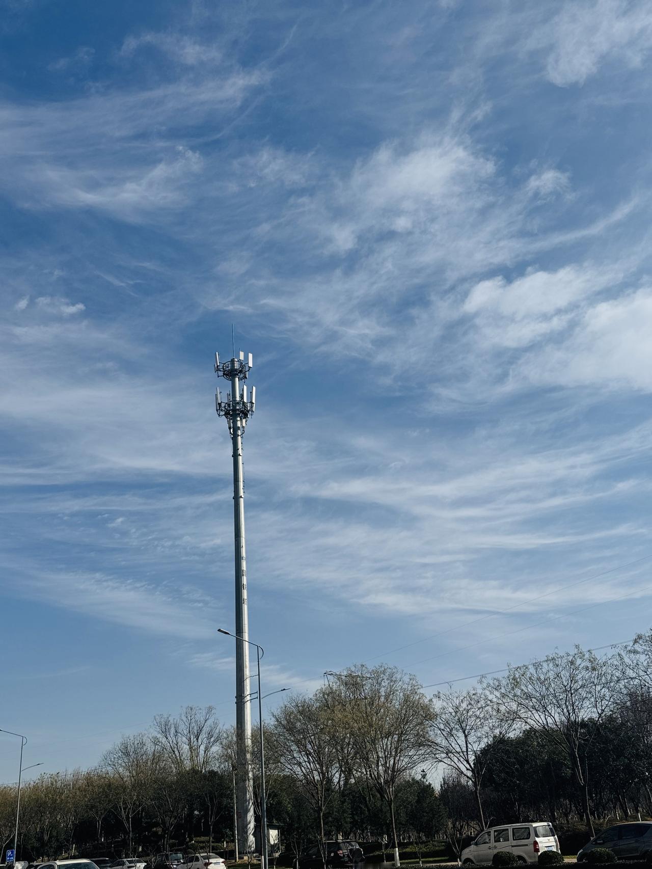 城市高楼与自然绿植的和谐共存，蓝天白云下的宁静生活。