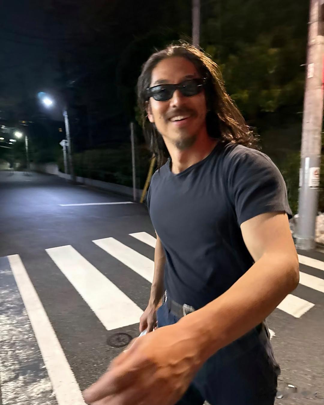 志玲老公黑泽良平在晚上的街头出现，打扮真的一言难尽，留着一头长发，胡须没刮，不修