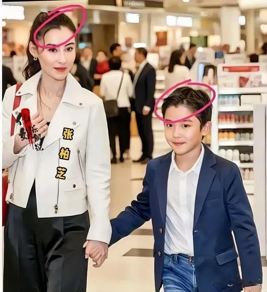 张柏芝牵着三儿子张承礼的手在商场，画面温馨幸福，儿子软萌可爱，样子机灵极了，长得