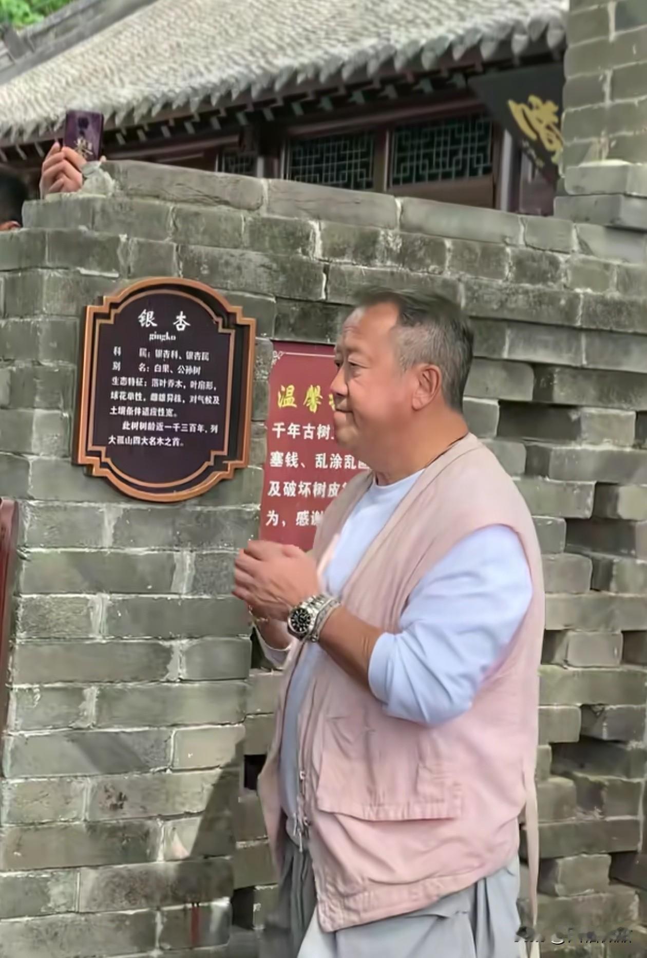 曾志伟现身丹东大孤山祈福，数十人的安保全队，场面盛大。

他一身休闲的衣服，浅色