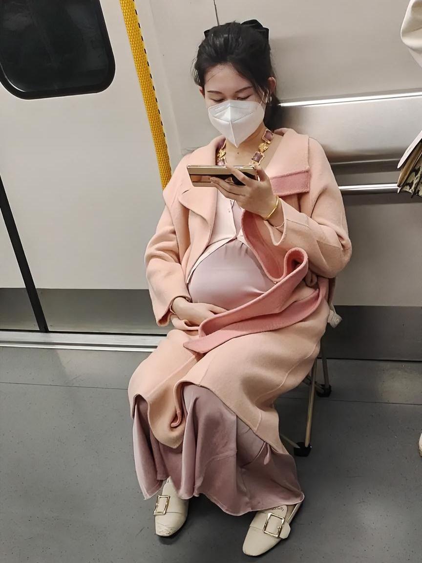 今天在地铁里看见一个怀孕的美女，可能是担心地铁里没有座位，她自己自带了一个折叠的