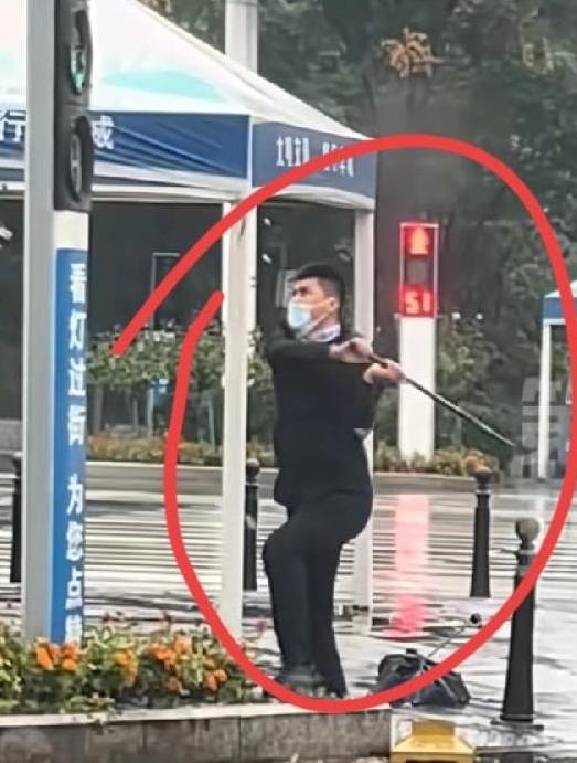 十堰红绿灯火了，男子手持铁棍，在街头暴砸，多个斑马线指示灯，看男子穿衣打扮很正常