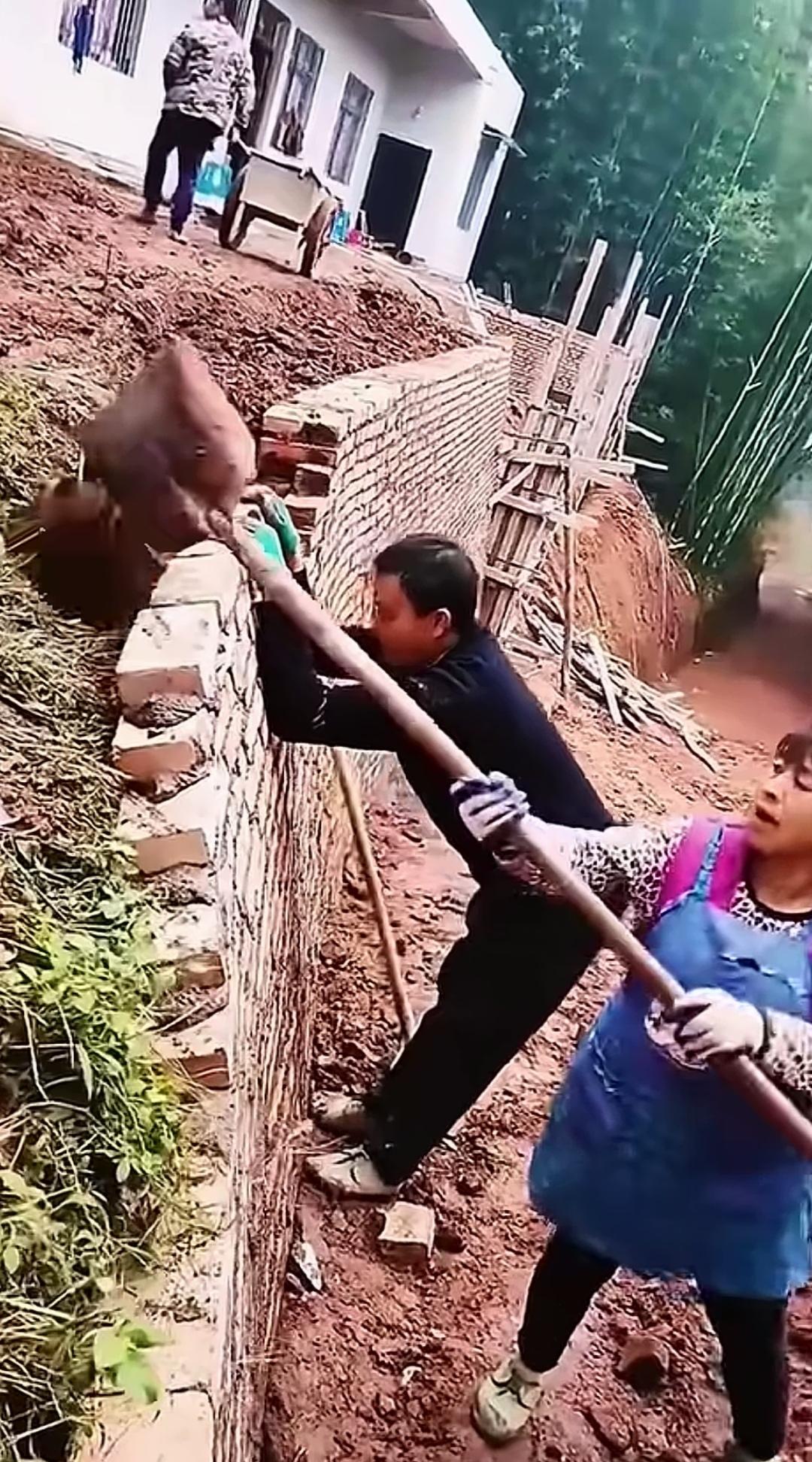 墙体已经向内倾斜，上手硬掰同时往里头填土，真能稳住吗？
还没砌完的挡土墙，墙身已