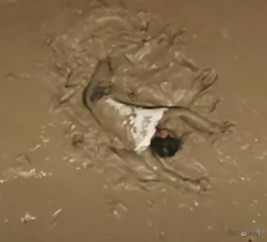 他们在泥泞中一点点往前挪动，只为了救起这个男子，可他们大多数还是孩子啊！

一名