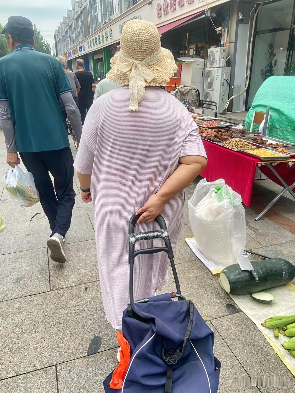 目测这个胖胖的阿姨体重足有150斤，穿着就像睡裙的衣服，没有腰线，显得更胖了！这
