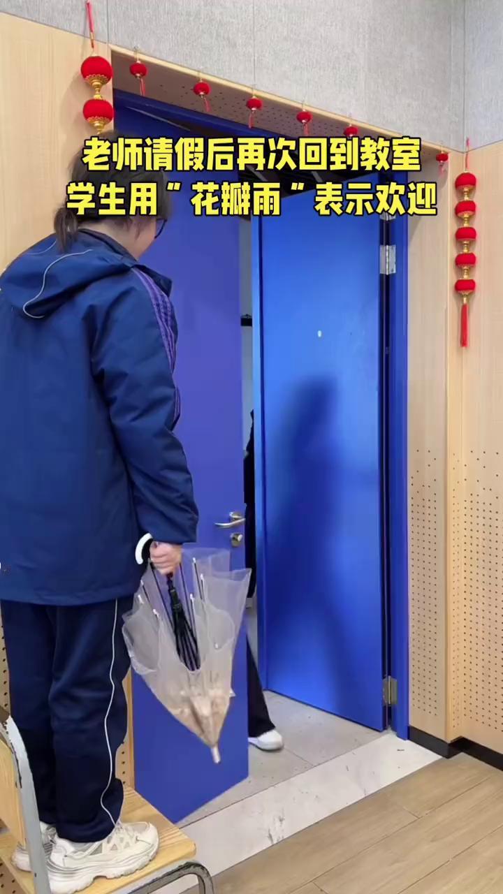 老师请假后再次回到教室，学生用"花瓣雨"表示欢迎。