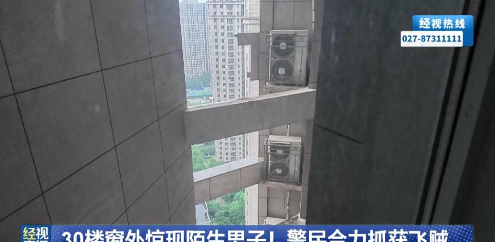 武汉汉江，一名住在30层的女子做饭时，发现窗外空调外机上竟然趴着一名陌生男子，复